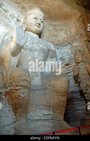 Yungang Grotten in der Nähe von Datong in der Provinz Shanxi, China. Große alte Statue von Buddha in einer Höhle bei Yungang. Seitenansicht im Hochformat Stockfoto