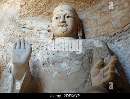 Yungang Grotten in der Nähe von Datong in der Provinz Shanxi, China. Große alte Statue von Buddha in einer Höhle bei Yungang. Landschaftsansicht von vorne Stockfoto