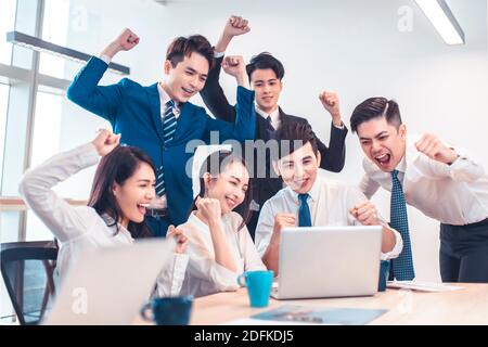 Das Business-Team des Unternehmens ist begeistert und sieht sich den Laptop in der Besprechung an Stockfoto