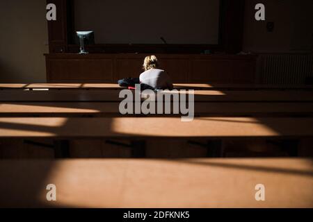 Ein Student arbeitet am 13. Oktober 2020 in einem Amphitheater an der Universität La Sorbonne in der Rue du Pantheon in Paris, Frankreich. Eine der größten öffentlichen Universitäten Frankreichs ist fest davon überzeugt, dass sie auf dem Campus keine "physische Distanz" aufzwingen wird, sondern sagt, dass sie die Bemühungen zum Schutz von Mitarbeitern und Studenten vor COVID-19 verstärkt hat. An der Universität Pantheon-Sorbonne wurden Handdesinfektionsdispenser installiert, wiederverwendbare Masken sind leicht verfügbar und der Zeitpunkt der Klassen wurde als Teil neuer Maßnahmen, die inmitten der Pandemie umgesetzt wurden, versetzt. Studierende der Universität haben die Möglichkeit, Stockfoto