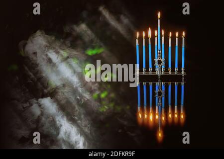 Hintergrund mit Rauch für Hanukkah. Blaue brennende Kerzen auf der Menora für den jüdischen Feiertag. Stockfoto