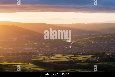 Die untergehende Sonne wirft an einem wechselhaften Dezembernachmittag ein dramatisches Licht über das Dorf Silsden im Aire-Tal. Stockfoto