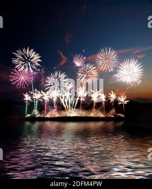 Buntes Feuerwerk verschiedenster Farben über den Nachthimmel, Feuerwerk am Strand Stockfoto