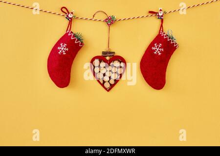 Weihnachten Hintergrund. Rote weihnachtssocken und Herz hängen am Seil auf goldenem Hintergrund. Speicherplatz kopieren. Stockfoto