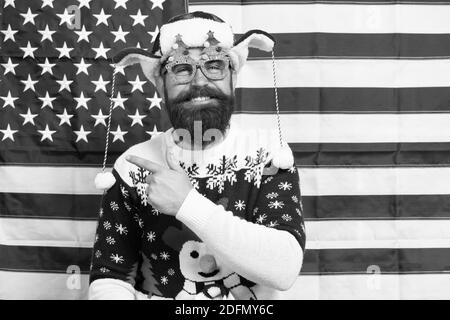 Hey look. Happy hipster Punkt Zeigefinger auf etwas. Bärtiger Mann zeigen und Lachen. Amerikanische Flagge im Hintergrund. Punkt Geste. Werbung zeigen. Frohe Weihnachten. Frohes neues Jahr. Stockfoto