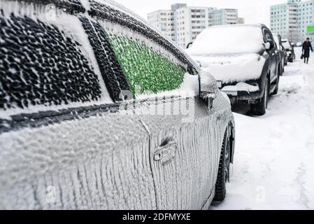 Auto mit Eis und Eiszapfen bedeckt nach Glatteisregen. Eissturmzyklon. Schneebedecktes Wetter. Stadt im Winter. Frostige Szenen im Winter. Stockfoto