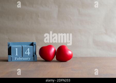 Der Holzkalender Februar 14 verfügt über zwei rote Herzen nebeneinander mit einem natürlichen Hintergrund platziert.Valentinstag. Stockfoto