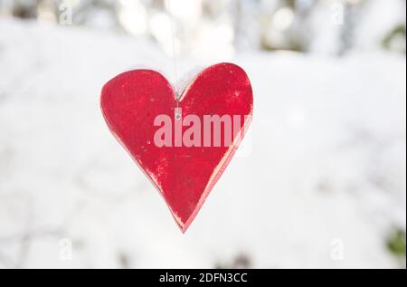 Holzherz vor schneebedecktem Hintergrund Stockfoto