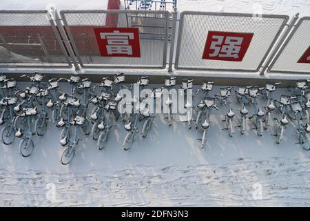 Yinchuan, China. Dezember 2020. Mobikes (Station-less Fahrrad-Sharing-System mit Sitz in Peking) werden von Schnee bedeckt auf der Ningxia Universität Hauptcampus gesehen. Kredit: SOPA Images Limited/Alamy Live Nachrichten Stockfoto