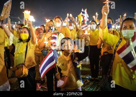 Bangkok, Thailand. Dezember 2020. Anhänger der thailändischen Königsfamilie halten Kerzen vor dem Großen Palast in Sanam Luang während einer Zeremonie, um den Geburtstag des verstorbenen thailändischen Königs Bhumibol Adulyadej (Rama 9) zu feiern. Der thailändische König Maha Vajiralongkorn (Rama 10) nahm zusammen mit anderen Mitgliedern der königlichen Familie an der Zeremonie Teil. Kredit: SOPA Images Limited/Alamy Live Nachrichten Stockfoto