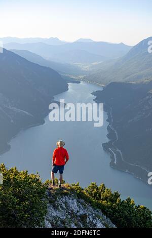 Bergsteiger, junger Mann mit Blick auf die Berglandschaft, Blick vom Baerenkopf auf den Achensee, Karwendel, Tirol, Österreich Stockfoto