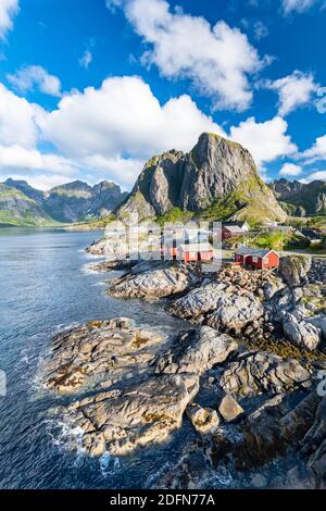 Rorbuer Fischerhütten am Fjord, Hamnoy, Reinefjord mit Bergen im Hintergrund, reine, Lofoten, Norwegen Stockfoto