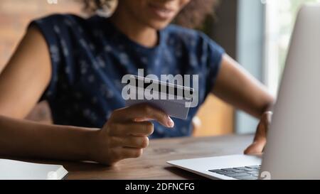 Nahaufnahme der Bankkarte in den weiblichen Händen mit gemischtem Rennen. Stockfoto