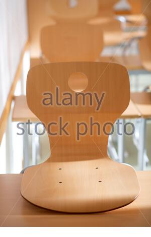 In einem verlassenen deutschen Klassenzimmer stehen Stühle auf Schultischen, während die Corona-Virus-Zahlen steigen. Stockfoto