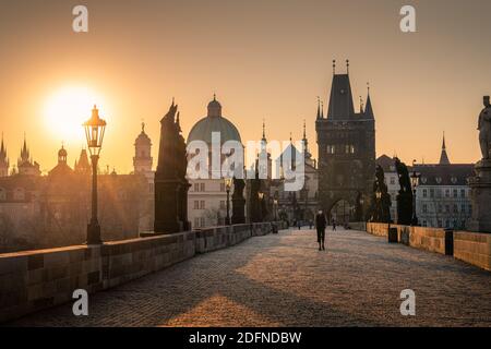 PRAG, TSCHECHISCHE REPUBLIK, APRIL 2020 - Mann in Atemschutzmaske während der covid Lockdown, Karlsbrücke bei Sonnenaufgang, Altstädter Brückenturm, Prag UNESCO, Tschechisch Stockfoto