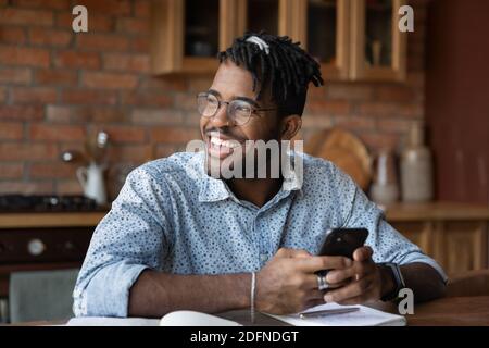 Glückliche junge afrikanische Ethnizität Mann mit Smartphone. Stockfoto