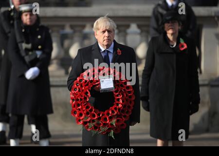 Datei Foto vom 08/11/20 von Premierminister Boris Johnson hält einen Mohnkranz, während er vor der ehemaligen Premierministerin Theresa May stand, während der Gedenksonntag im Cenotaph, in Whitehall, London. Am 13. Dezember 2020 jährt sich zum ersten Mal der Wahlsieg von Johnson. Stockfoto