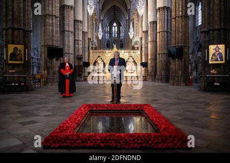 File photo dated 07/05/20 of the Dean of Westminster, Reverend Dr David Hoyle (left) Blick auf Premierminister Boris Johnson zündet eine Kerze am Grab des Unbekannten Kriegers in Westminster Abbey in London, vor den gedenkfeiern zum 75. Jahrestag des VE Day. Am 13. Dezember 2020 jährt sich zum ersten Mal der Wahlsieg von Johnson. Stockfoto