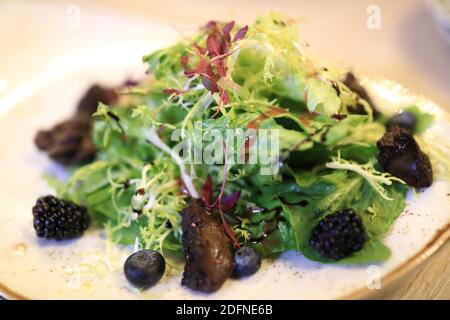 Teller mit Hühnerleber-Salat im Restaurant Stockfoto