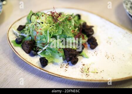 Hähnchenleber-Salat auf dem Teller im Restaurant Stockfoto