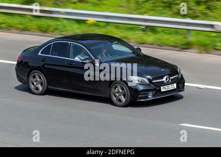 2020 schwarz Mercedes-Benz C 300 AMG Line Edition E; Fahrzeugverkehr, fahrende Fahrzeuge, Hybrid-Elektro-Limousine, Fahrzeug auf britischen Straßen, Motoren, Fahren auf der Autobahn M6 Autobahn UK Straßennetz. Stockfoto