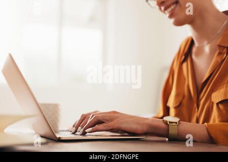 Zugeschnittene Aufnahme einer Frau, die auf einem Laptop schreibt. Geschäftsfrau, die von zu Hause aus mit einem Laptop arbeitet. Stockfoto