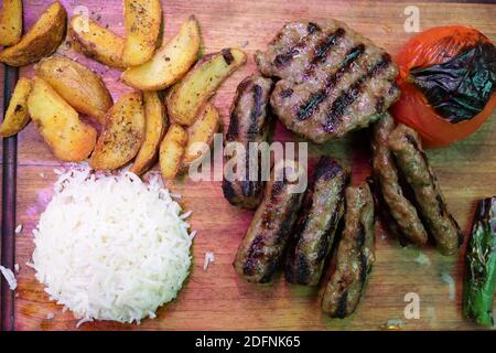 Verschiedene Kebabs und Gemüse auf Holzbrett Stockfoto