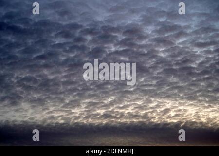 Sonnenuntergangshimmel mit kleinen Zirruswolken in verschiedenen Pastellfarben. Das Foto kann als Hintergrund oder abstrakt dienen. Stockfoto