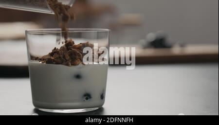 Granola mit Blaubeeren im Glas mit Kopierraum, breites Foto Stockfoto