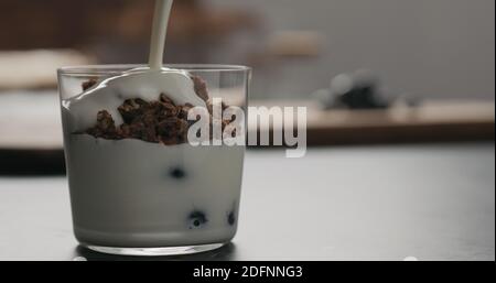 Granola mit Blaubeeren im Glas mit Kopierraum, breites Foto Stockfoto