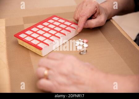 Sortieren von Pillen, ältere Hände Sortieren von Pillen , Pillen in den Händen eines Senior. Schmerzhaftes Alter. Pflege der Gesundheit älterer Menschen Stockfoto