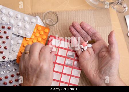 Sortieren von Pillen, ältere Hände Sortieren von Pillen , Pillen in den Händen eines Senior. Schmerzhaftes Alter. Pflege der Gesundheit älterer Menschen Stockfoto