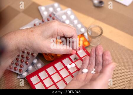 Sortieren von Pillen, ältere Hände Sortieren von Pillen , Pillen in den Händen eines Senior. Schmerzhaftes Alter. Pflege der Gesundheit älterer Menschen Stockfoto