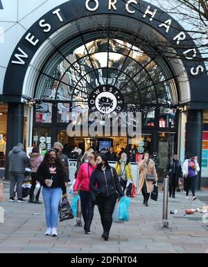 Coventry, Großbritannien. Dezember 2020. Menschen mit Gesichtsmasken verlassen West Orchards Shopping Center, während sie Einkaufstaschen tragen.am ersten Wochenende der neuen Coronavirus-Beschränkungen, ist die Stadt Coventry in der Tier 3 - "sehr hohes Risiko" mit keinen Pubs oder Restaurants dürfen Handel, außer für Takeaways, Aber alle Geschäfte sind offen und Käufer in Kraft. Kredit: SOPA Images Limited/Alamy Live Nachrichten Stockfoto