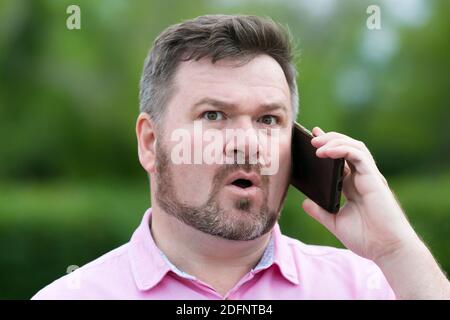 Der Mann ist schockiert über die Nachricht öffnete seinen Mund überrascht. Stockfoto