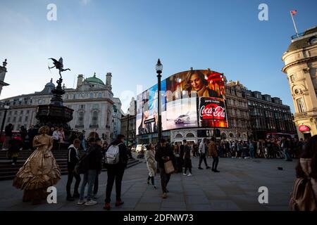 LONDON, Großbritannien - 25. MÄRZ 2019: Teil des Piccadilly Circus am Abend, der große Mengen von Menschen draußen zeigt Stockfoto