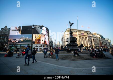 LONDON, Großbritannien - 25. MÄRZ 2019: Teil des Piccadilly Circus am Abend, der große Mengen von Menschen draußen zeigt Stockfoto