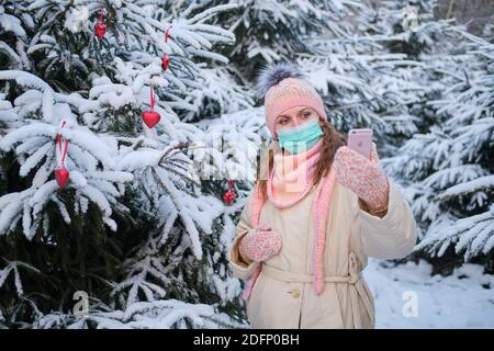 Frau in medizinischen Maske chatten online für weihnachten am Silvesterabend - Moskau, Russland, 02. Dezember 2020 Stockfoto