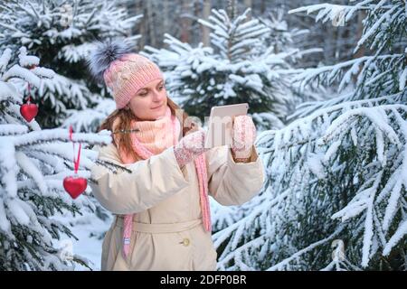 Lächelnde Frau, die online zu Weihnachten am Silvesterabend spricht - Moskau, Russland, 02. Dezember 2020 Stockfoto