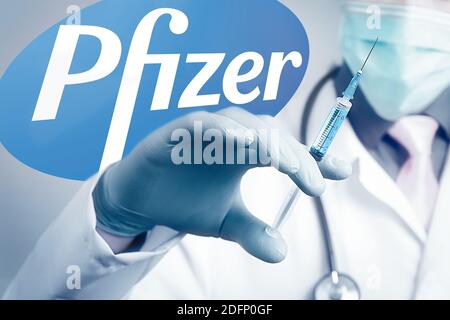 Pfizer BioNTech Impfstoff gegen Coronavirus COVID Krankheit. Spritze in Arzthand und Logo Pfizer auf dem Hintergrund. Illustratives Editorial Stockfoto
