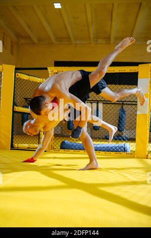 Zwei männliche MMA-Kämpfer kämpfen in einem Käfig Stockfoto