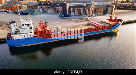 Frachtschiff, das Getreide in seine offenen Rümpfe in einem Hafen lädt. Stockfoto
