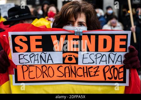 Madrid, Spanien. Dezember 2020. Ein Protestler mit einem Plakat mit der Aufschrift "zum Verkauf stehende Schmerzen" während einer Demonstration, die vor dem Abgeordnetenkongreß marschiert, um gegen die Regierung zu protestieren und den Rücktritt von Präsident Pedro Sanchez zu fordern, zeitgleich mit dem zentralen Akt am Tag der Feier der spanischen Verfassung, die im Inneren gefeiert wird Der Kongress der Abgeordneten. Quelle: Marcos del Mazo/Alamy Live News Stockfoto