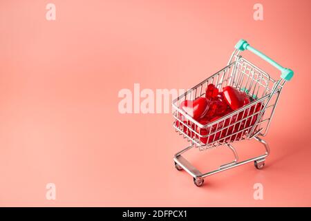 Warenkorb voller Herzen zum Valentinstag auf rosa Hintergrund Stockfoto