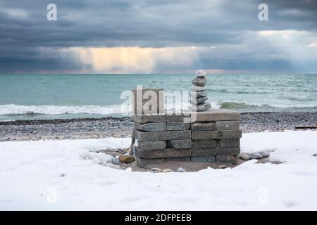 Gestapelte Steine und dramatischer Himmel an einem kalten Wintertag im Waterfront Park in Pickering, Ontario. Stockfoto