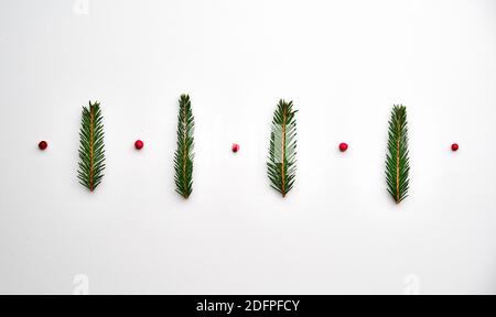 Kreativer Rahmen aus Tannenzweigen auf weißem Hintergrund mit Dekoration. Grußkarte, Winterurlaub. Flach liegend Stockfoto