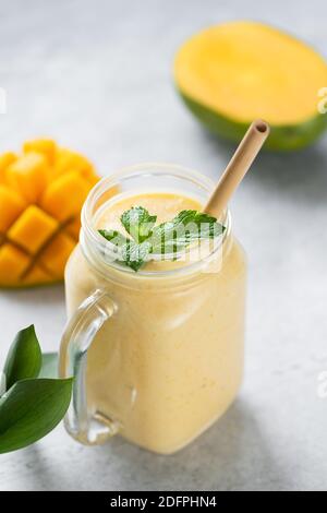 Mango Smoothie oder Mango Lassi in Glas mit Bambus Trinkhalm Stockfoto