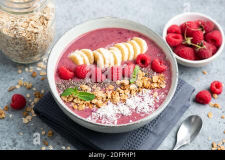 Rosafarbene Himbeer-Smoothie-Schale mit Superfood-Toppings. Gesunde vegane Smoothie Schüssel Stockfoto