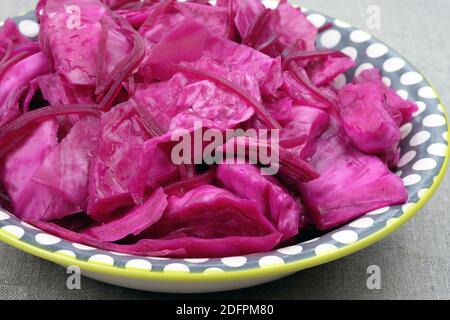 Kohl mit Rübensalat auf einem Teller. Sauerkraut mit Rüben. Eingelegter Kohl mit Rüben auf einem Teller auf dem Tisch Stockfoto