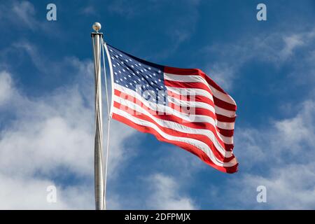 Amerikanische Flagge, die gegen den blauen Himmel fliegt Stockfoto